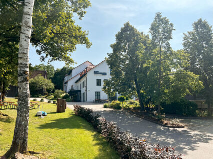 Außenansicht des Hotels Der Hermannsberg mit Blick auf das Hotelgebäude und Grünanlagen.