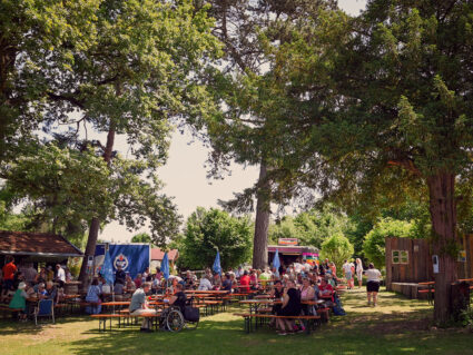 Feiern im Der Hermannsberg - Zahlreiche Gäste genießen Food-Trailer, Bier-Ausschank und gutes Essen im Schatten unter Bäumen