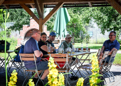 Feiern im Der Hermannsberg - Zahlreiche Gäste genießen einen sonnigen Tag im überdachten Bereich